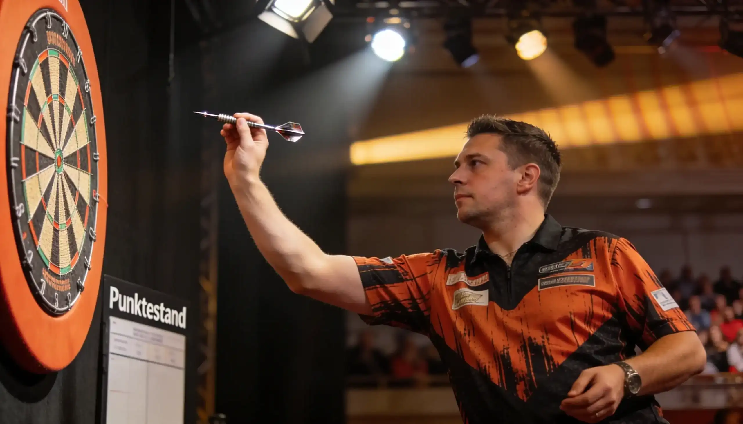 Darts-Wettarten: Dartspieler wirft am Oche bei einem PDC-Turnier